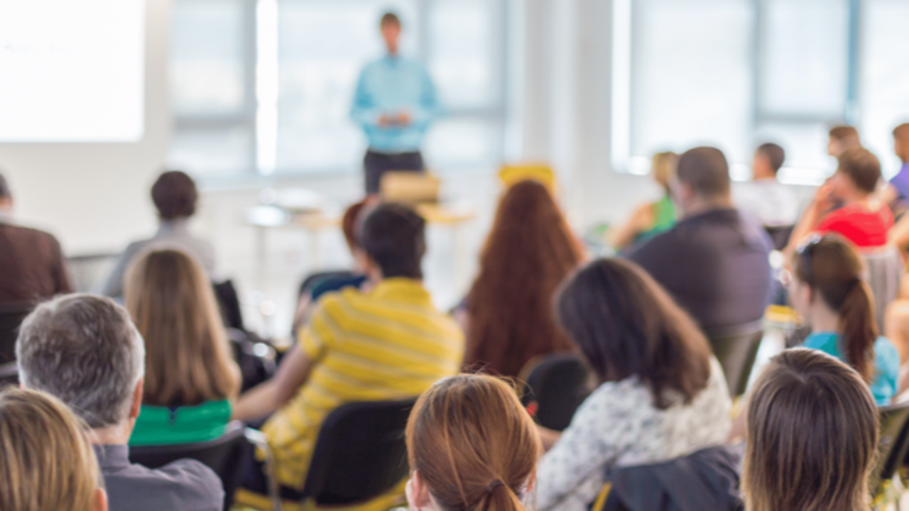 Person presenting to a room full of people