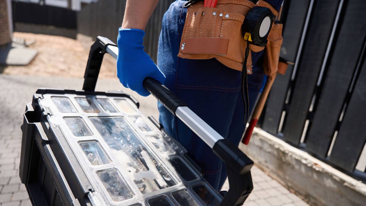 Worker carrying toolbox in a work site