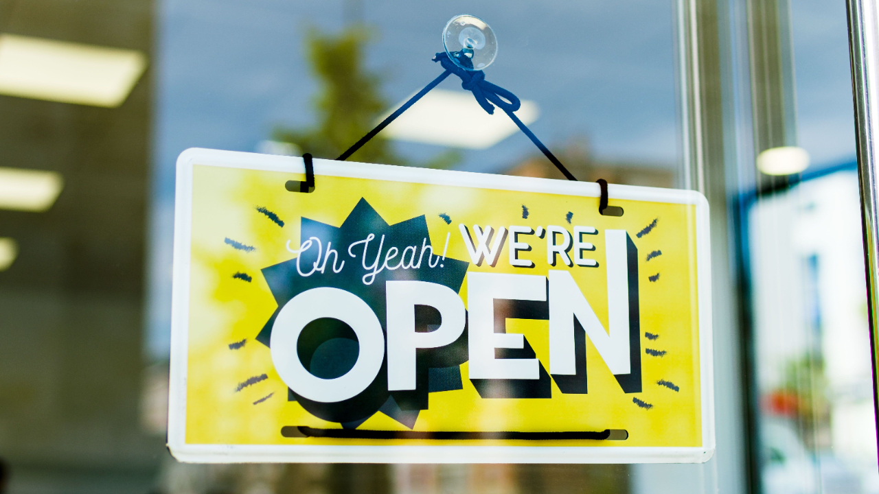 Storefront window a sign saying oh yeah we’re open