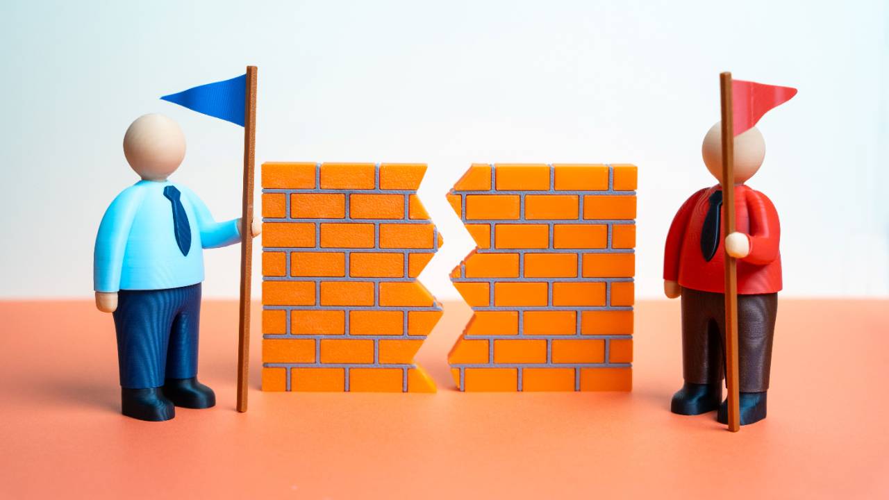 Figure holding flag next to broken brick wall