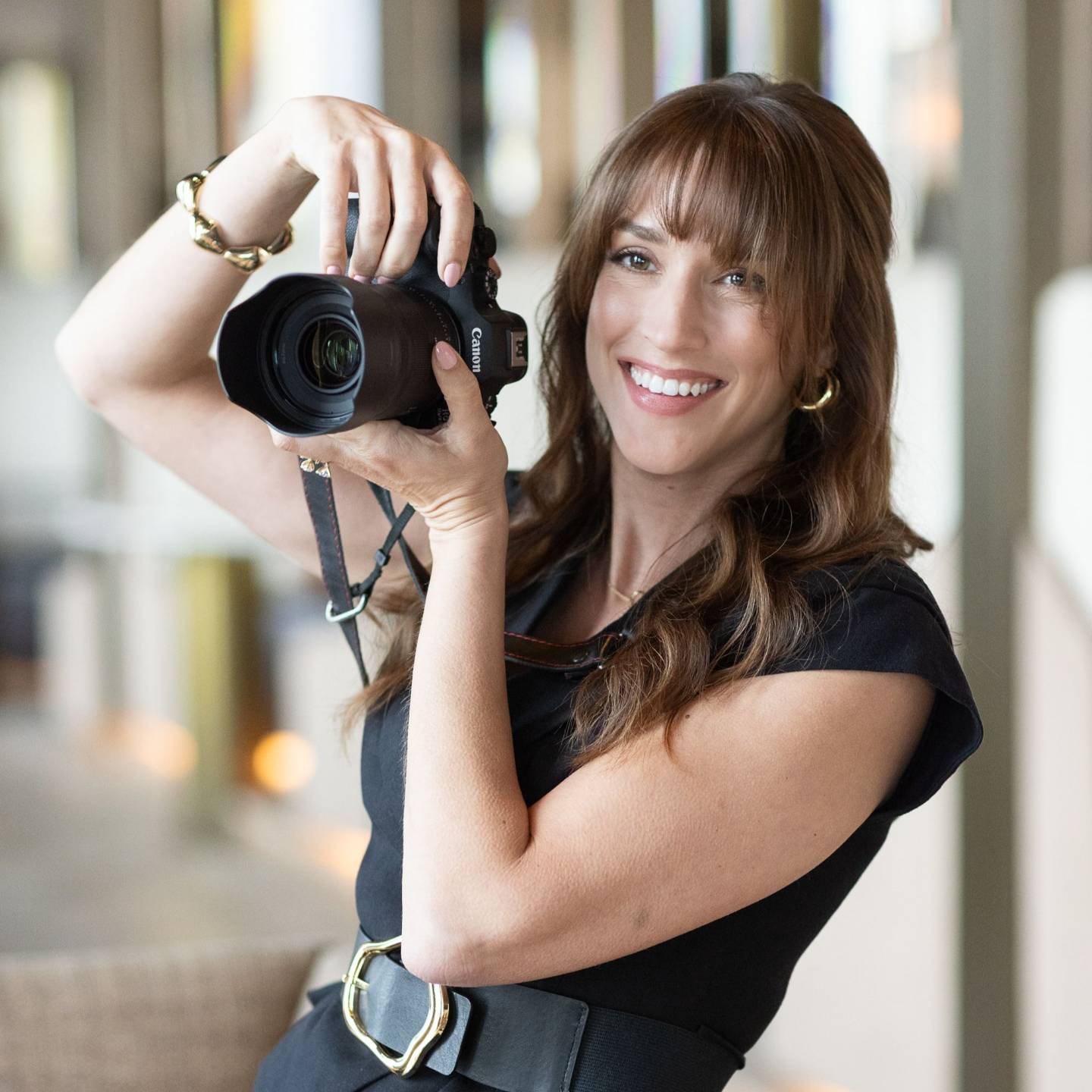 Vanessa Joy, wedding photographer, smiling while holding her camera up to take a photo