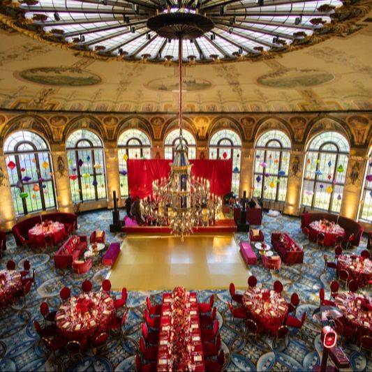 Aerial view of a wedding reception ballroom with red and gold decor