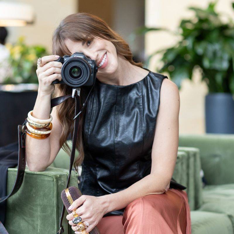 Vanessa Joy, wedding photography business coach, holding a Canon camera up to her eye