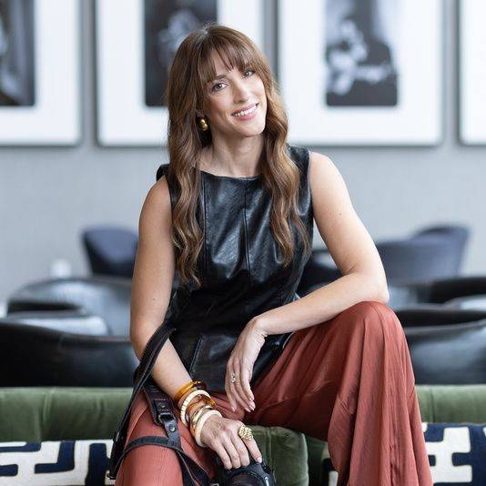 Vanessa Joy, smiling, seated with her camera