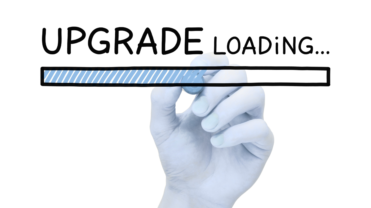 A hand drawing a loading bar beneath the words Upgrade Loading on a white background, representing the Inner Empire™ truth that the most important upgrade a woman in midlife can make is not to her habits but to her identity.