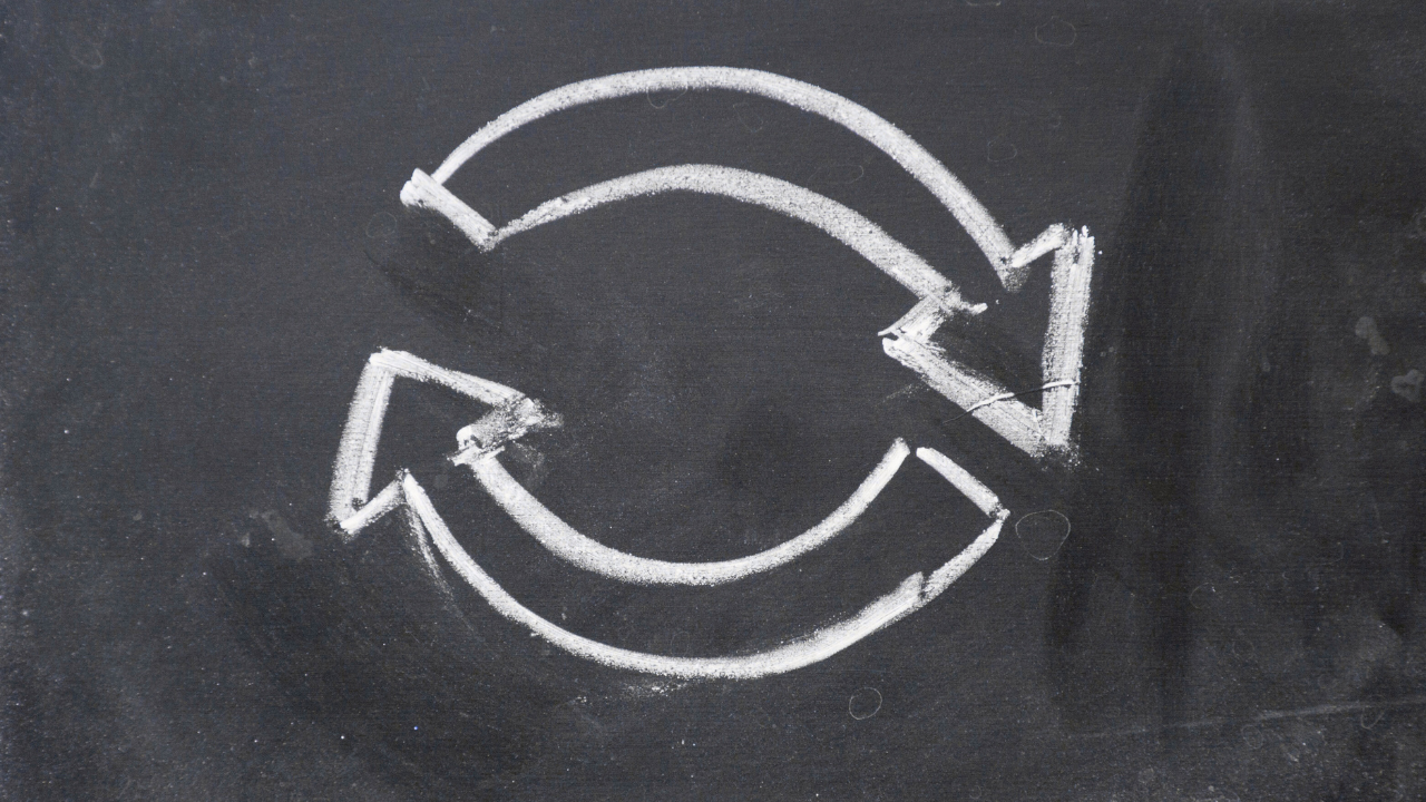 Two chalk arrows forming a continuous loop on a dark chalkboard, representing the Inner Empire™ truth that overthinking is a cycle the mind cannot break alone and the body holds the way out.