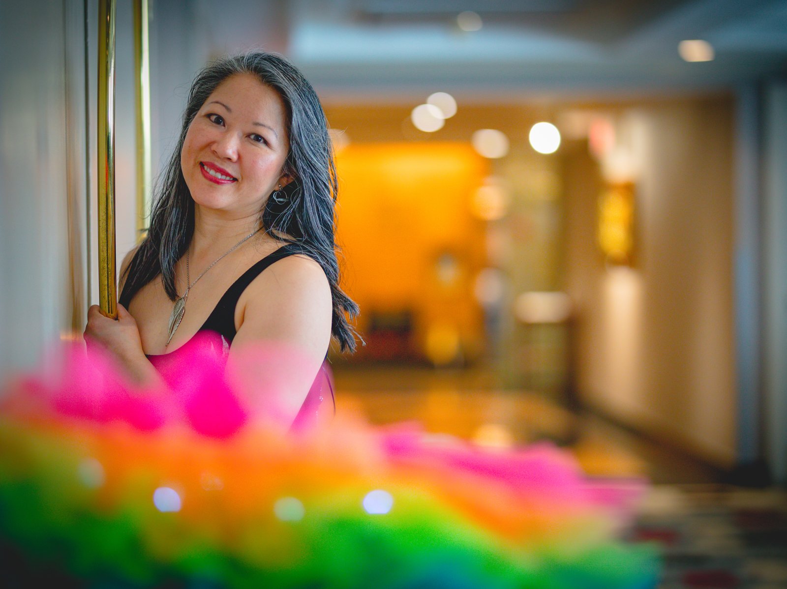 Dr. Karen Kan G smiling in a rainbow tutu, with warm golden light behind her
