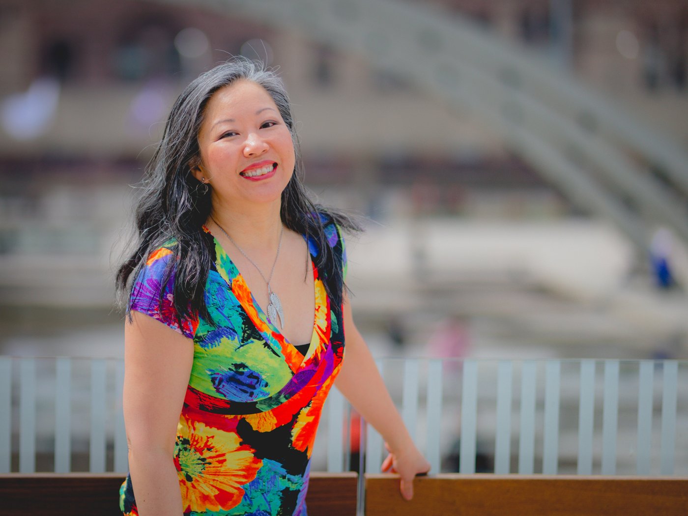 Dr. Karen Kan G smiling outdoors in a colorful floral dress
