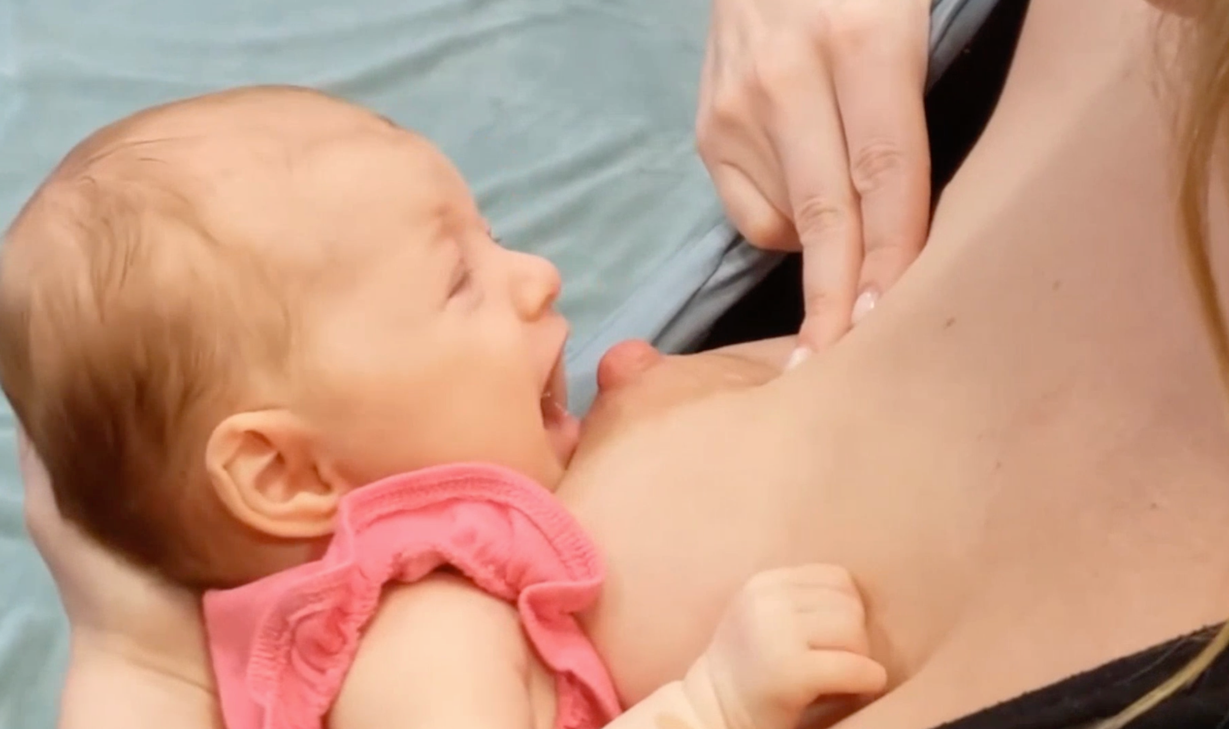 Two fingers gently moving the nipple without lifting the entire breast