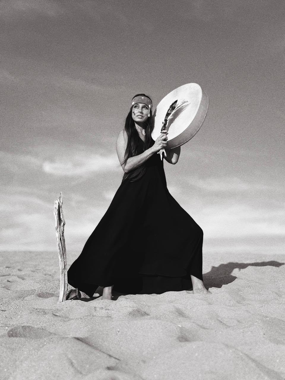 Réka Fodor in profile wearing a shell headpiece with her hand raised