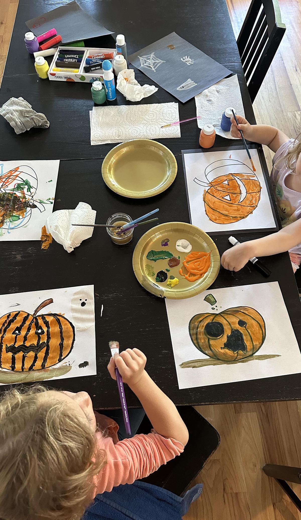 Daniel's kids painting pumpkins at the family table