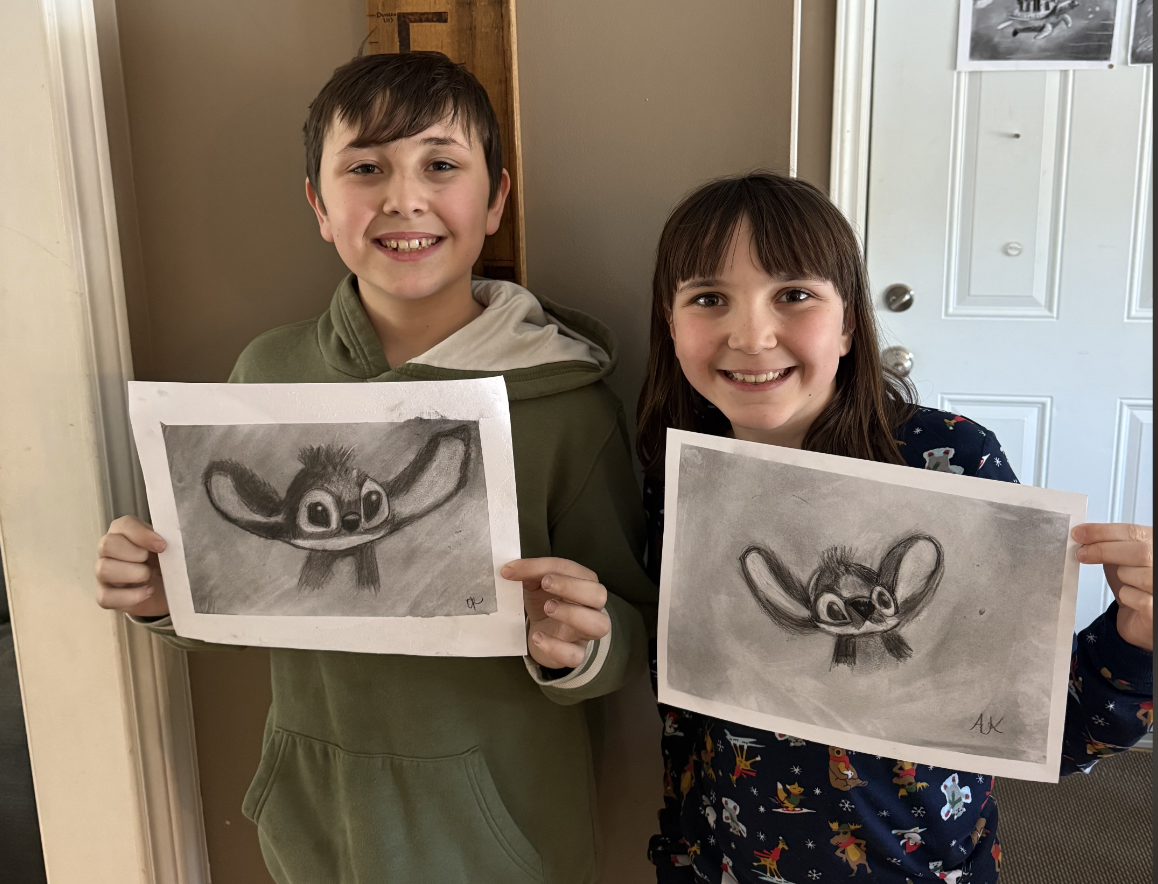 Students holding their shaded artwork from a previous workshop