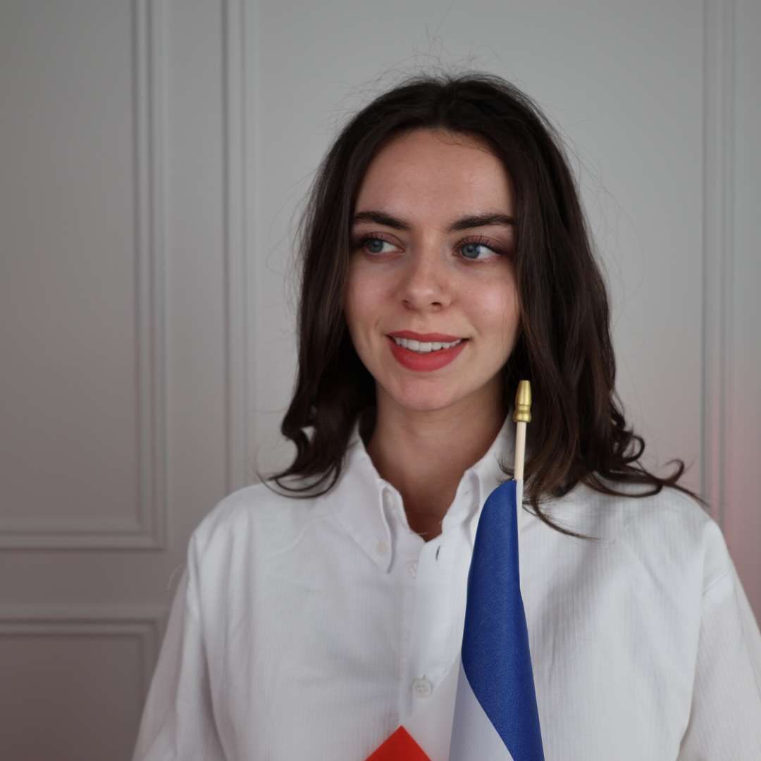 Clémence, French teacher and course founder, smiling in a cozy sweater