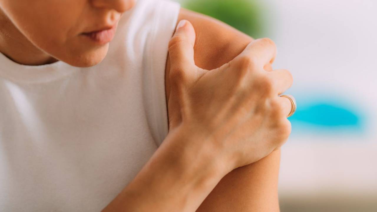 person holding their shoulder in pain