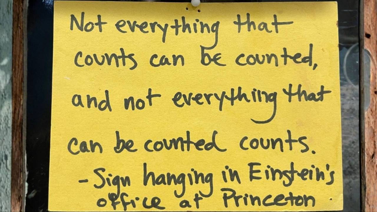 Inspirational quote attributed to Albert Einstein displayed on a yellow sign: 'Not everything that counts can be counted, and not everything that can be counted counts,' photographed outside Einstein's office at Princeton University.