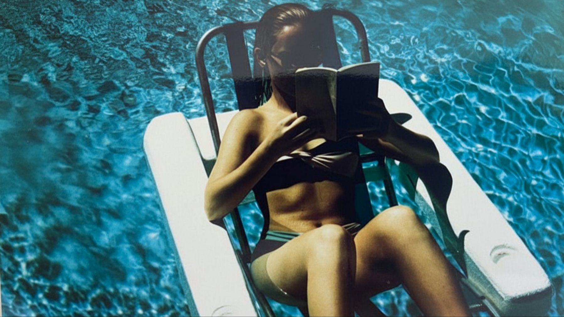 teenager reading in a pool