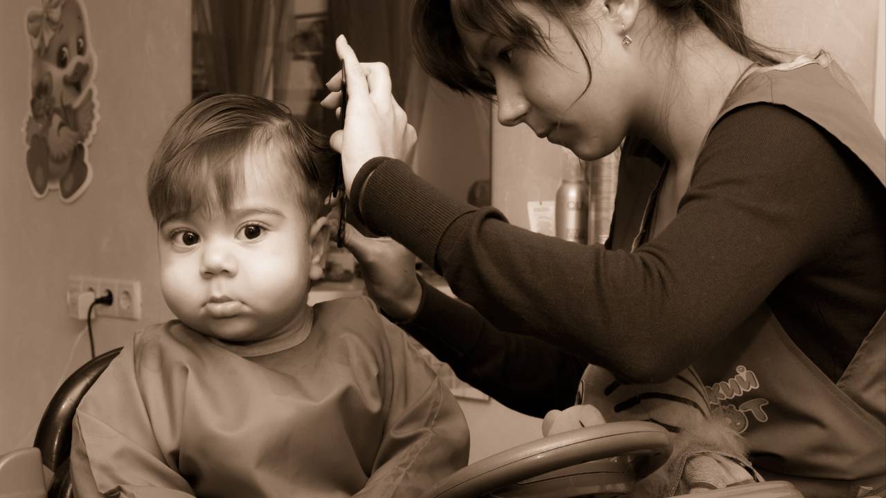 Teen giving a baby a haircut