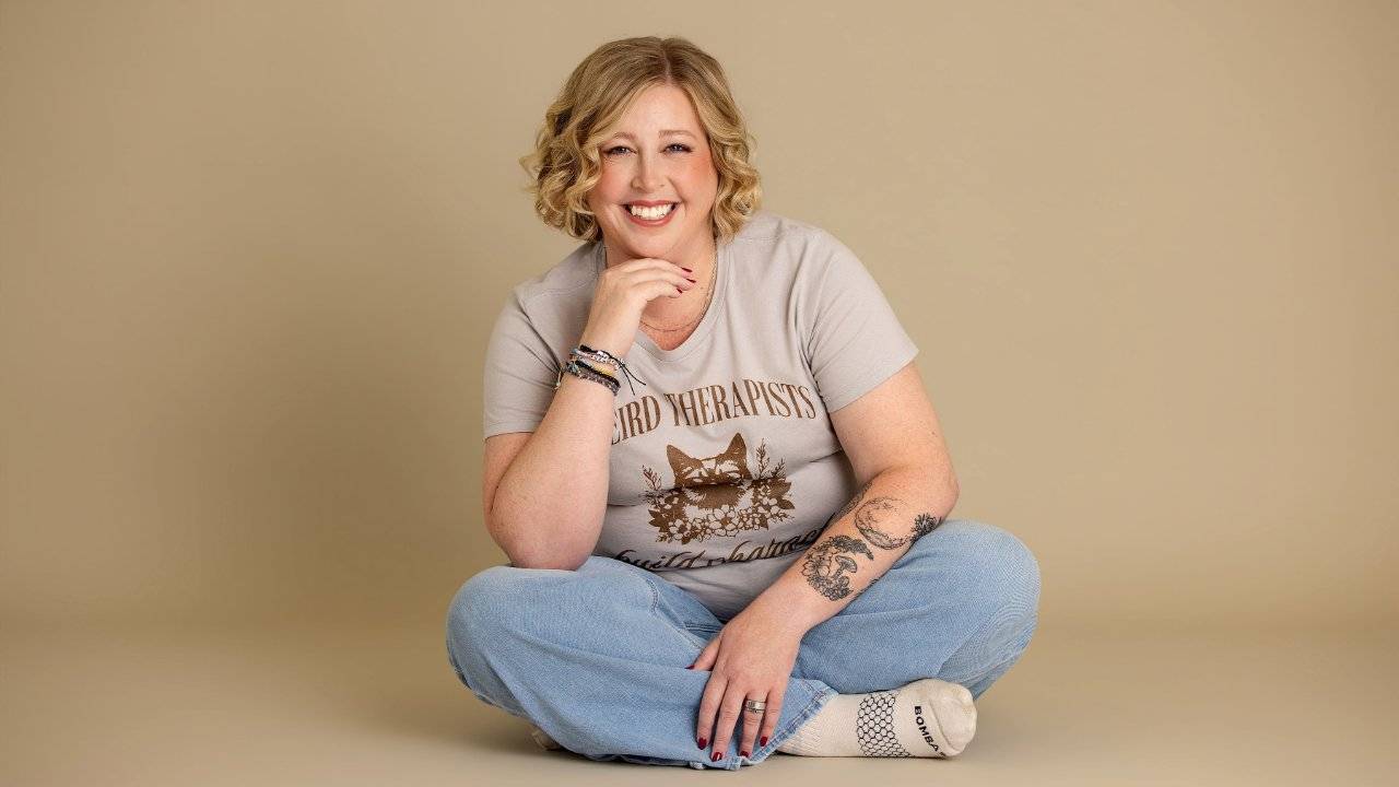 Becca Gerlach sitting cross-legged and smiling, psychedelic preparation and integration therapist, Plymouth, Michigan