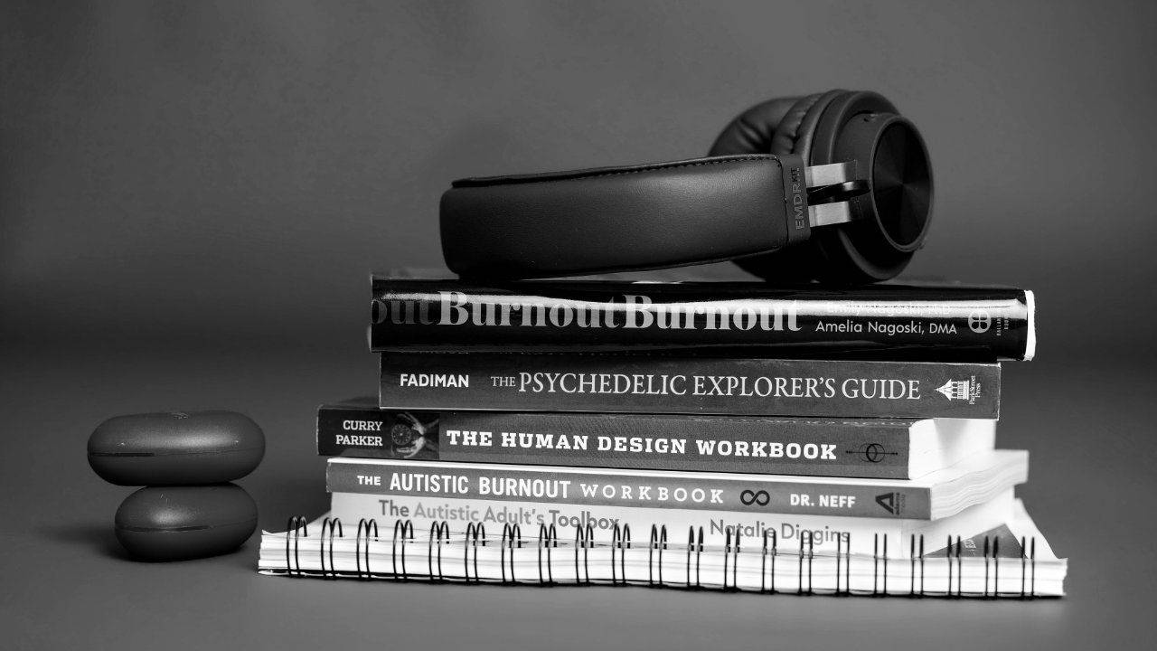 Noise-canceling headphones on a stack of books, sensory overload at work, Plymouth, Michigan therapist