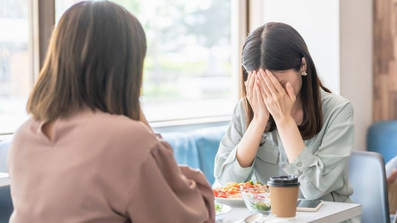 A woman crying in front of her female manager at a restaurant..