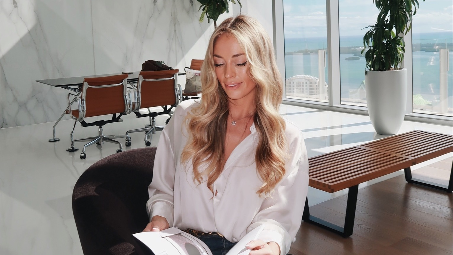 Brittany Arnason in a room with a beautiful waterfront view reviewing documents.