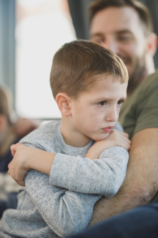 A boy sitting with his father