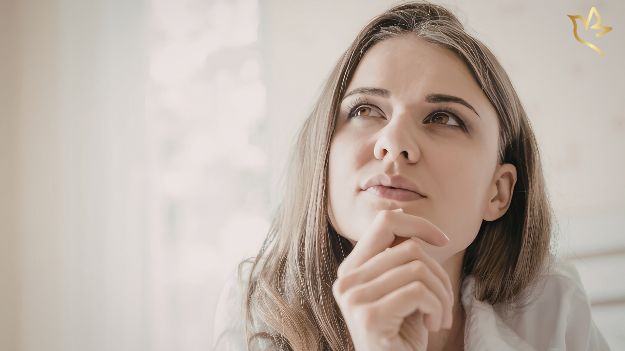 Thoughtful woman looking upward while considering how to share a funeral fundraiser and ask others for support.