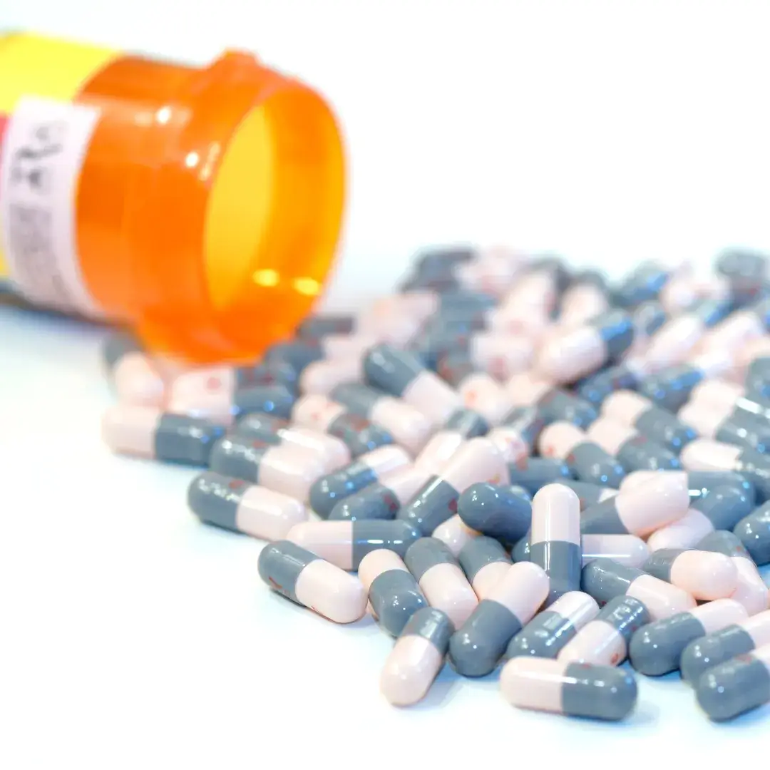 Prescription bottle tipped over with capsules spilling out