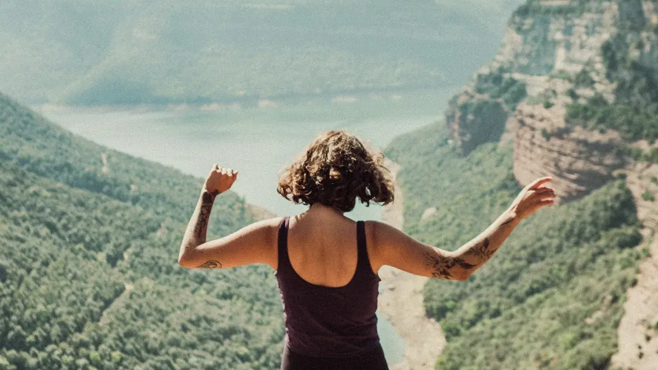 Person standing on a hillside looking out over an open view