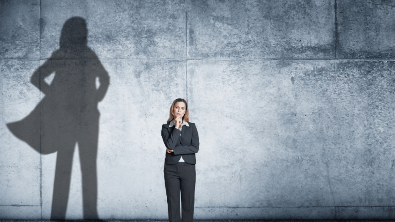Woman standing in front of a superhero-shaped shadow, representing shadow work therapy near me