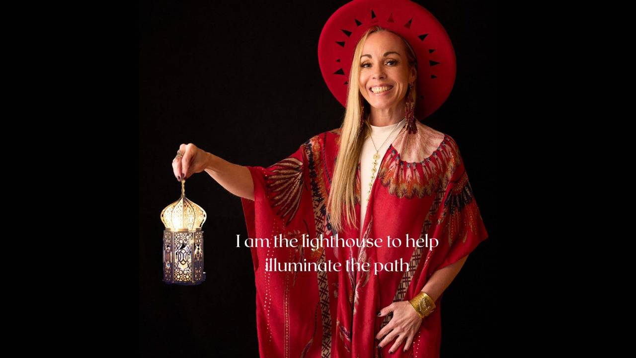 Dawn Light Amora, spiritual life coach in Santa Rosa, holding a lit lantern with the words I am the lighthouse to help illuminate the path