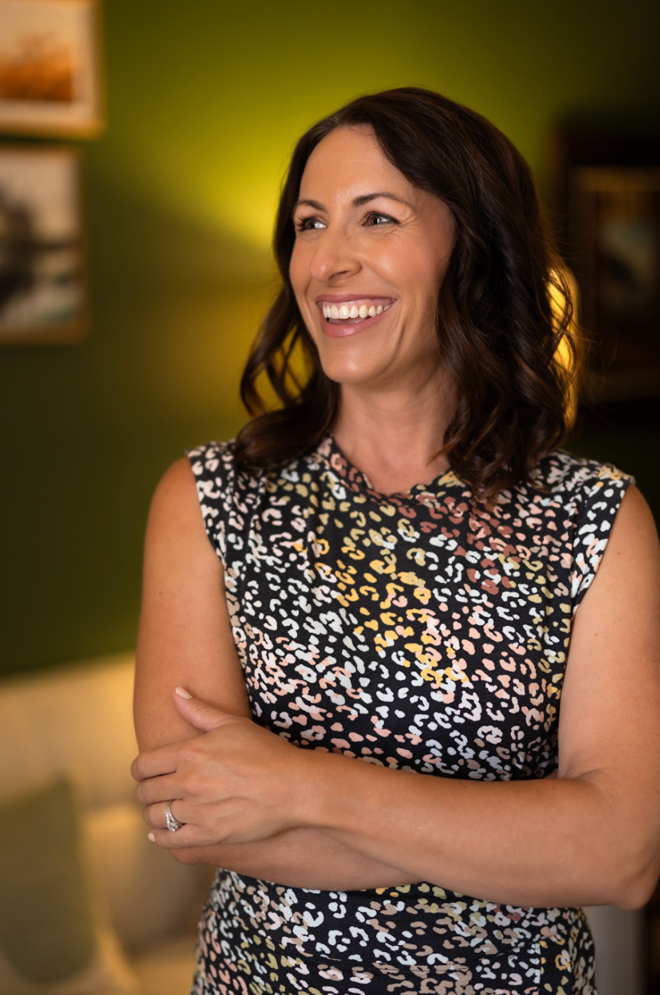 Dr. Lesley Tate-Gould smiling with her arms crossed in her therapy office — Somatic therapist Orange County CA
