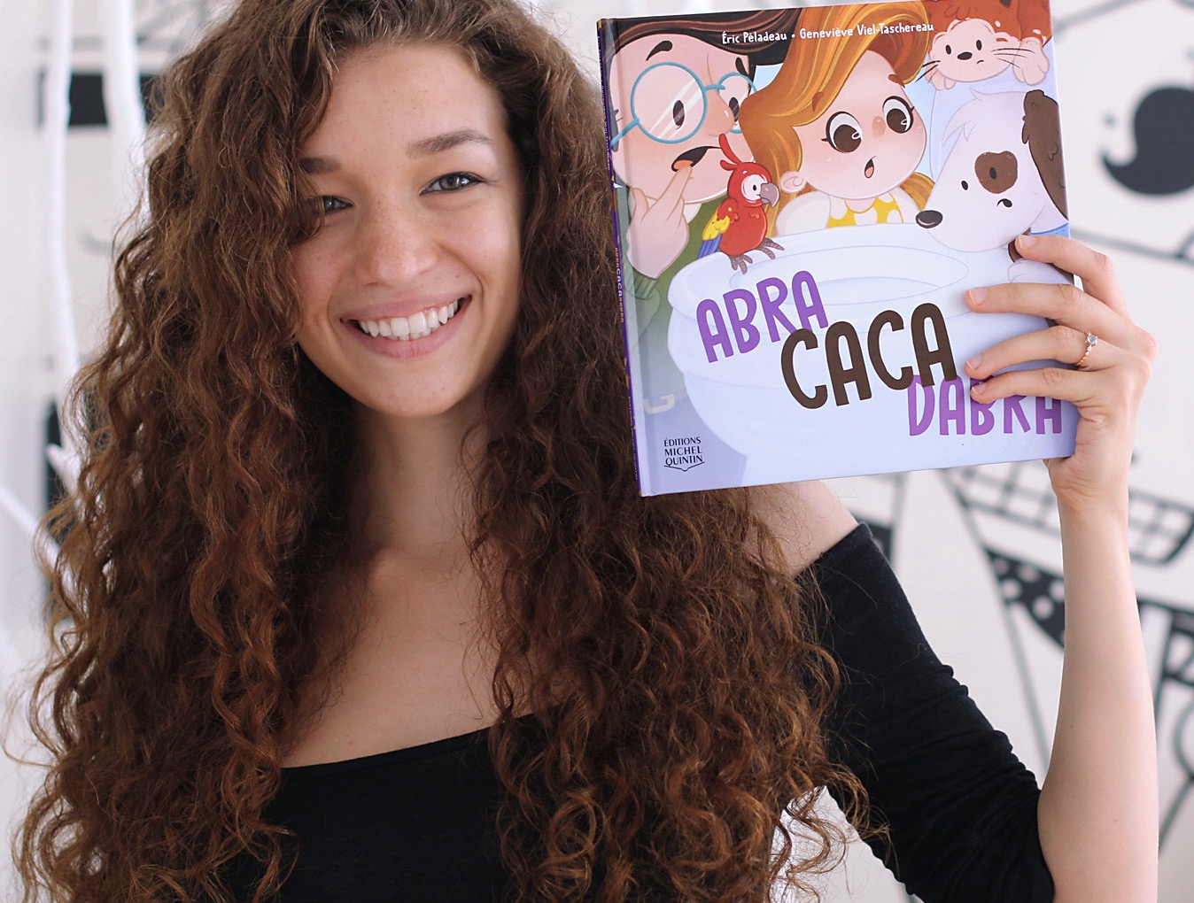 Genevieve holding Abracacadabra, a children's book she illustrated