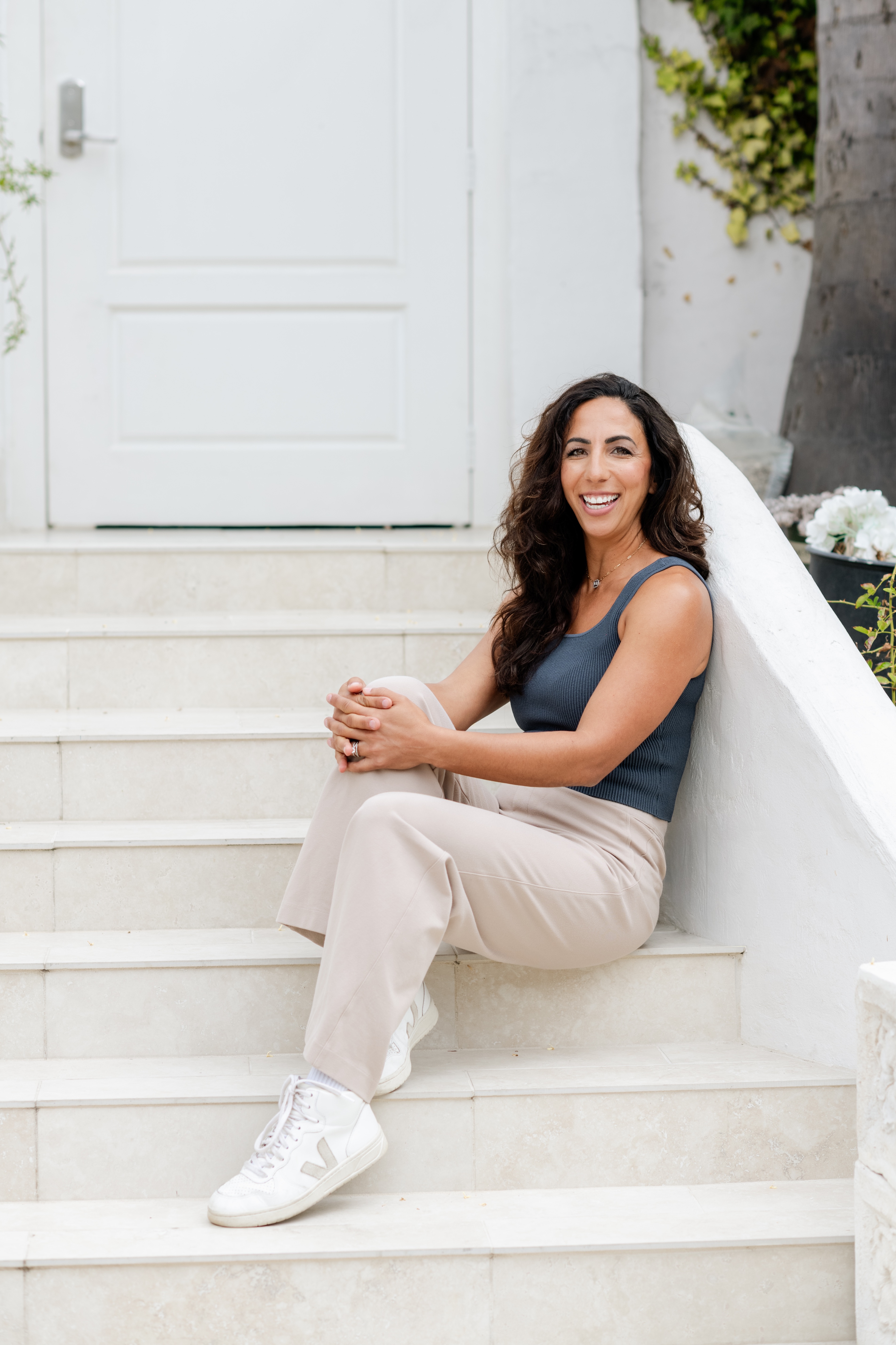 Dr. Helen Porat smiling, sitting on white steps