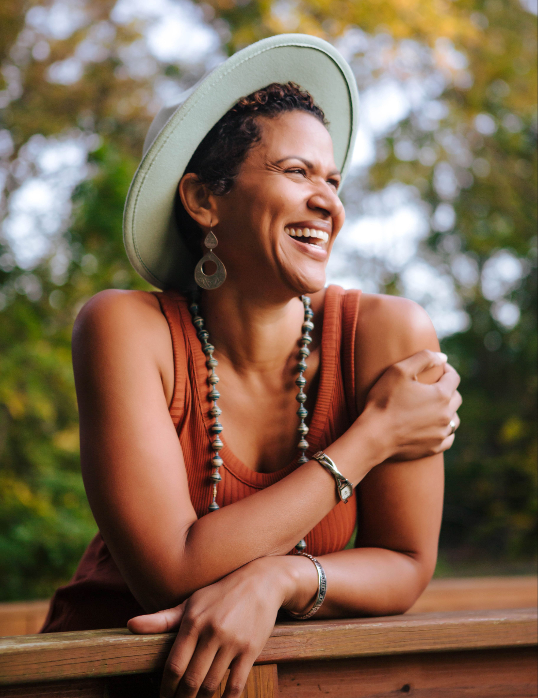 Woman smiling using a hat, watching to her side