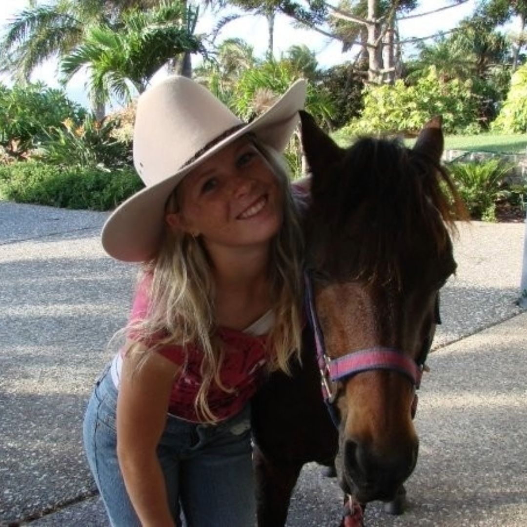 Nadine as a girl in a wide-brimmed hat, leaning cheek to cheek with a bay pony