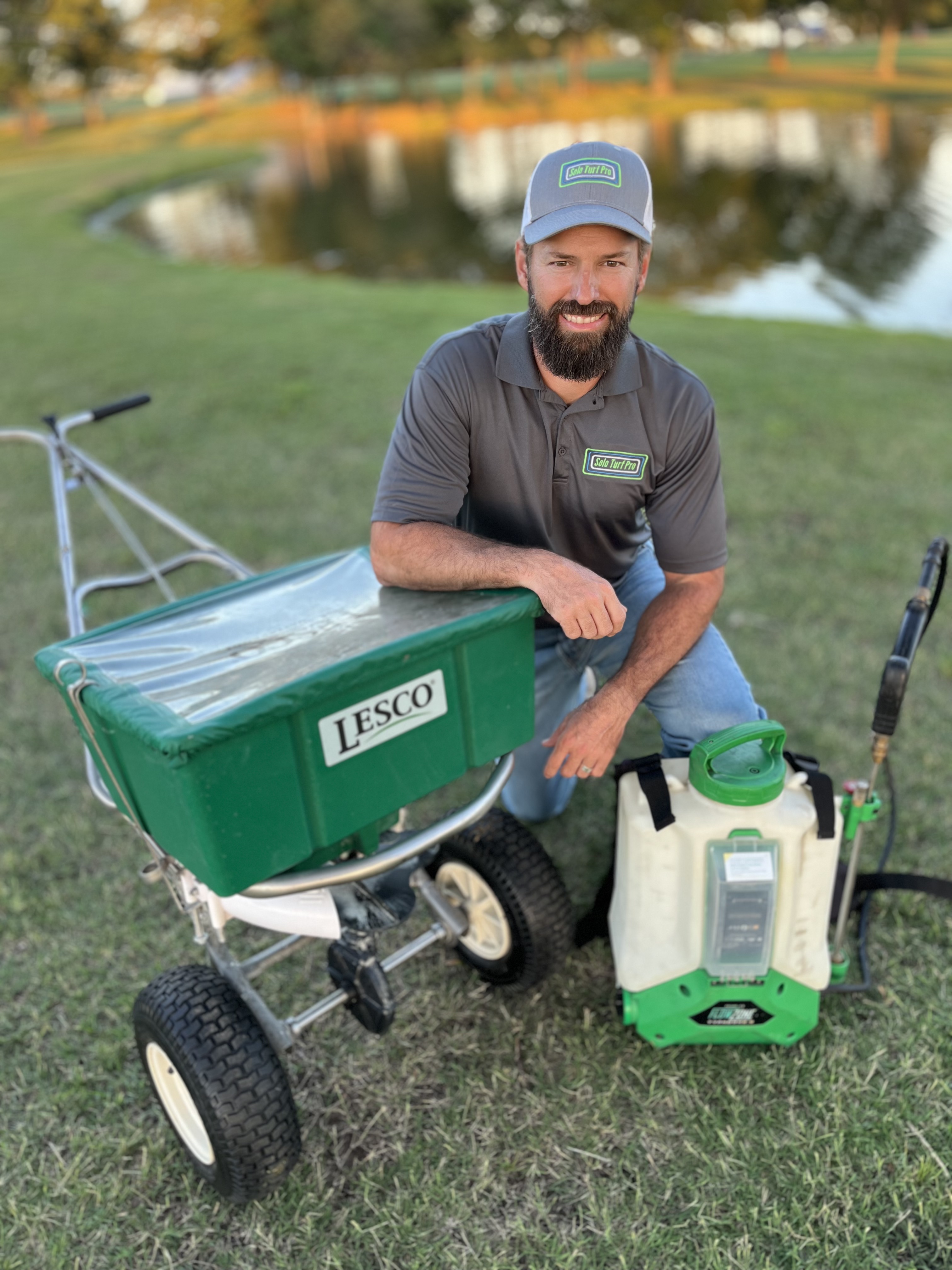 Jason Spears with his spreader on a lawn