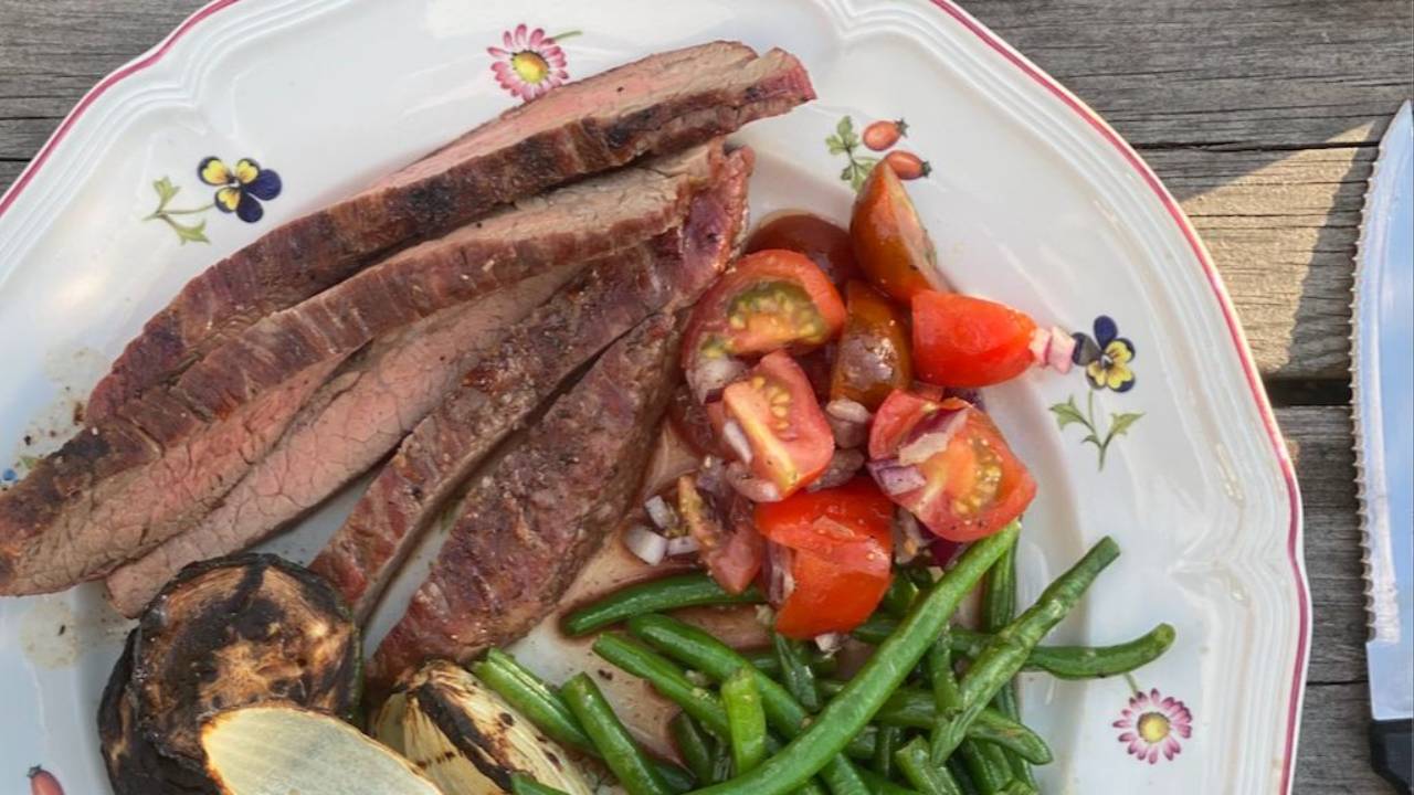 Grillat kött med tomatsallad på en tallrik