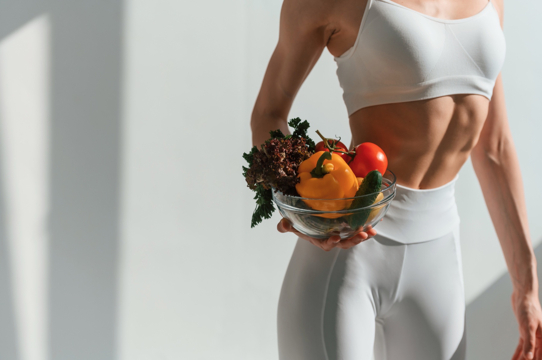 Athletic woman holding fresh vegetables