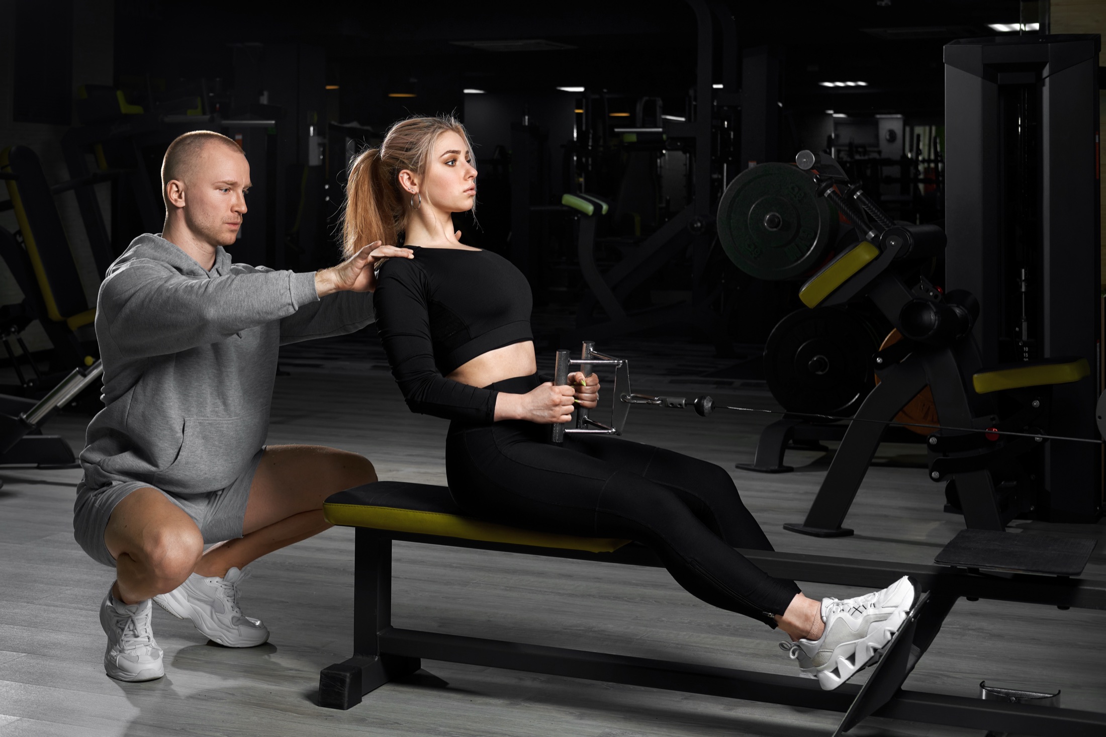 Personal trainer coaching a client during a seated cable row