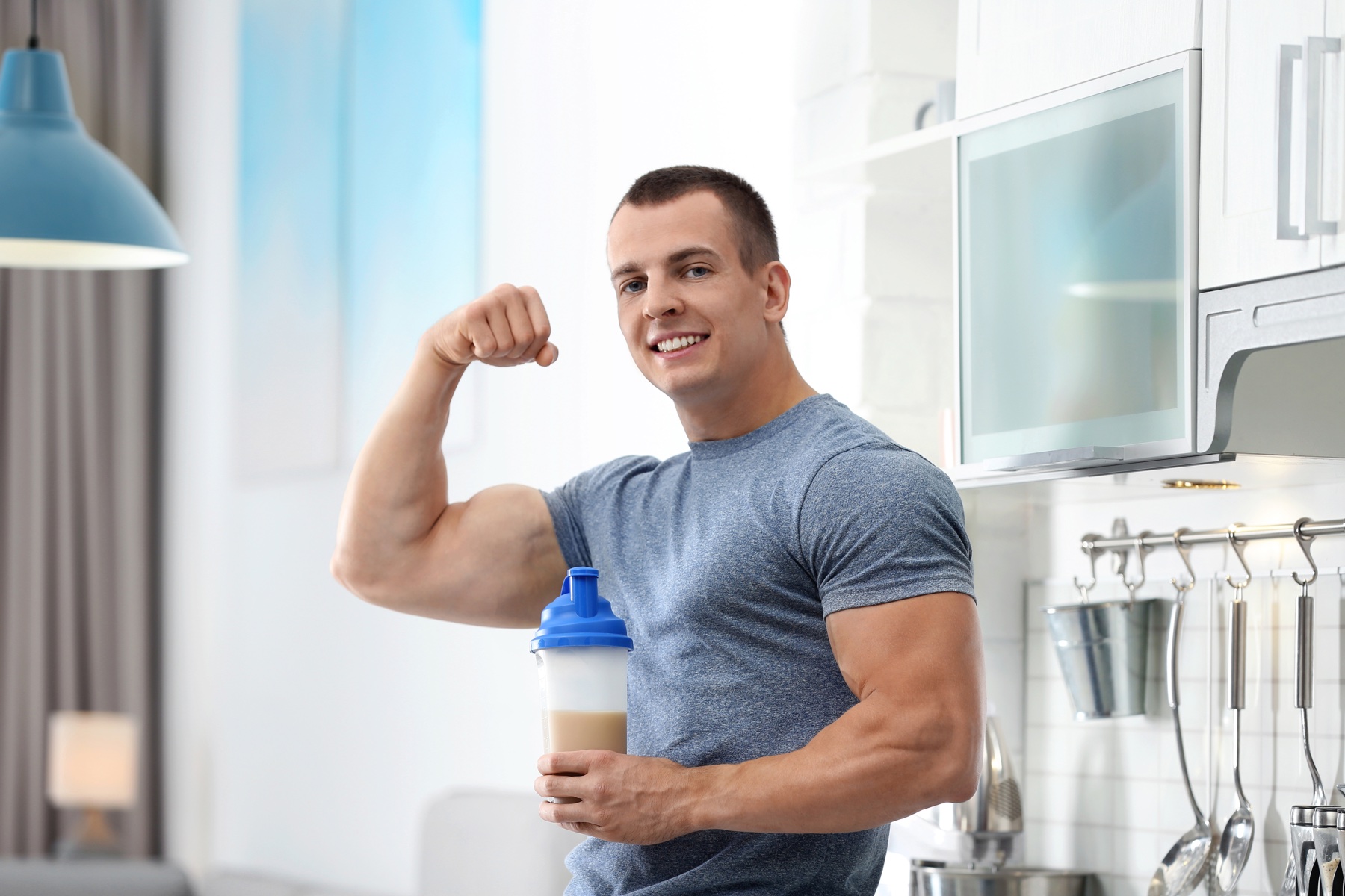 Athletic man with a protein shake in the kitchen