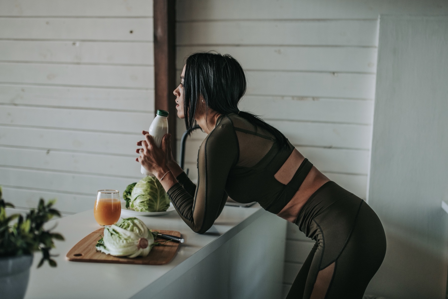 Athletic woman making nutrition choices in the kitchen
