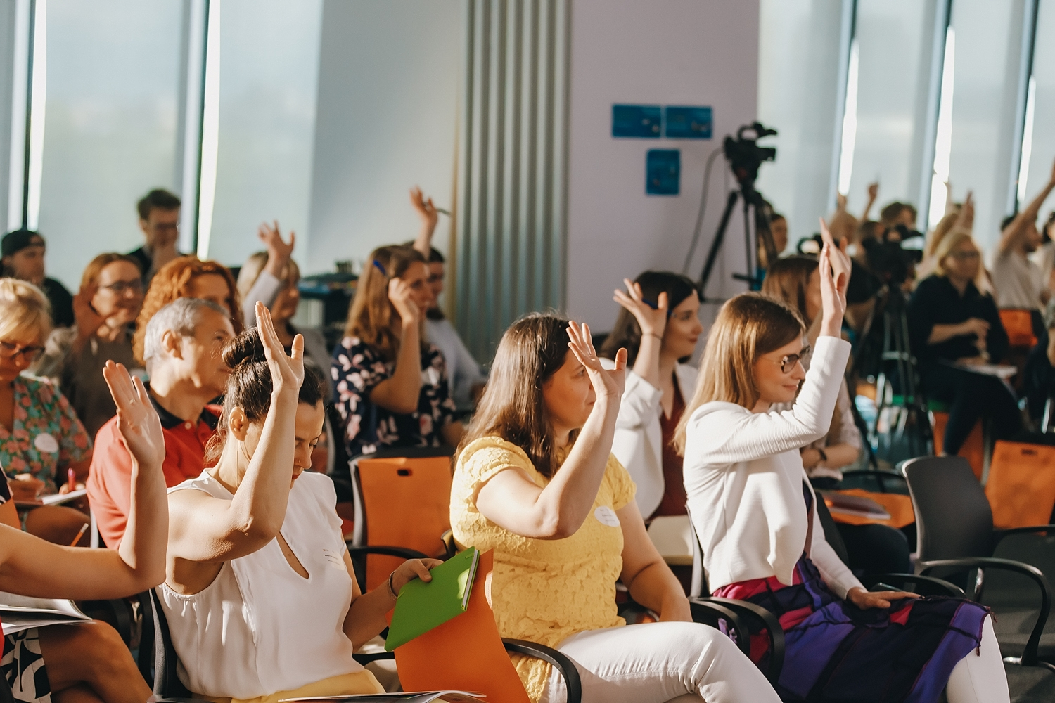 An engaged audience with hands raised