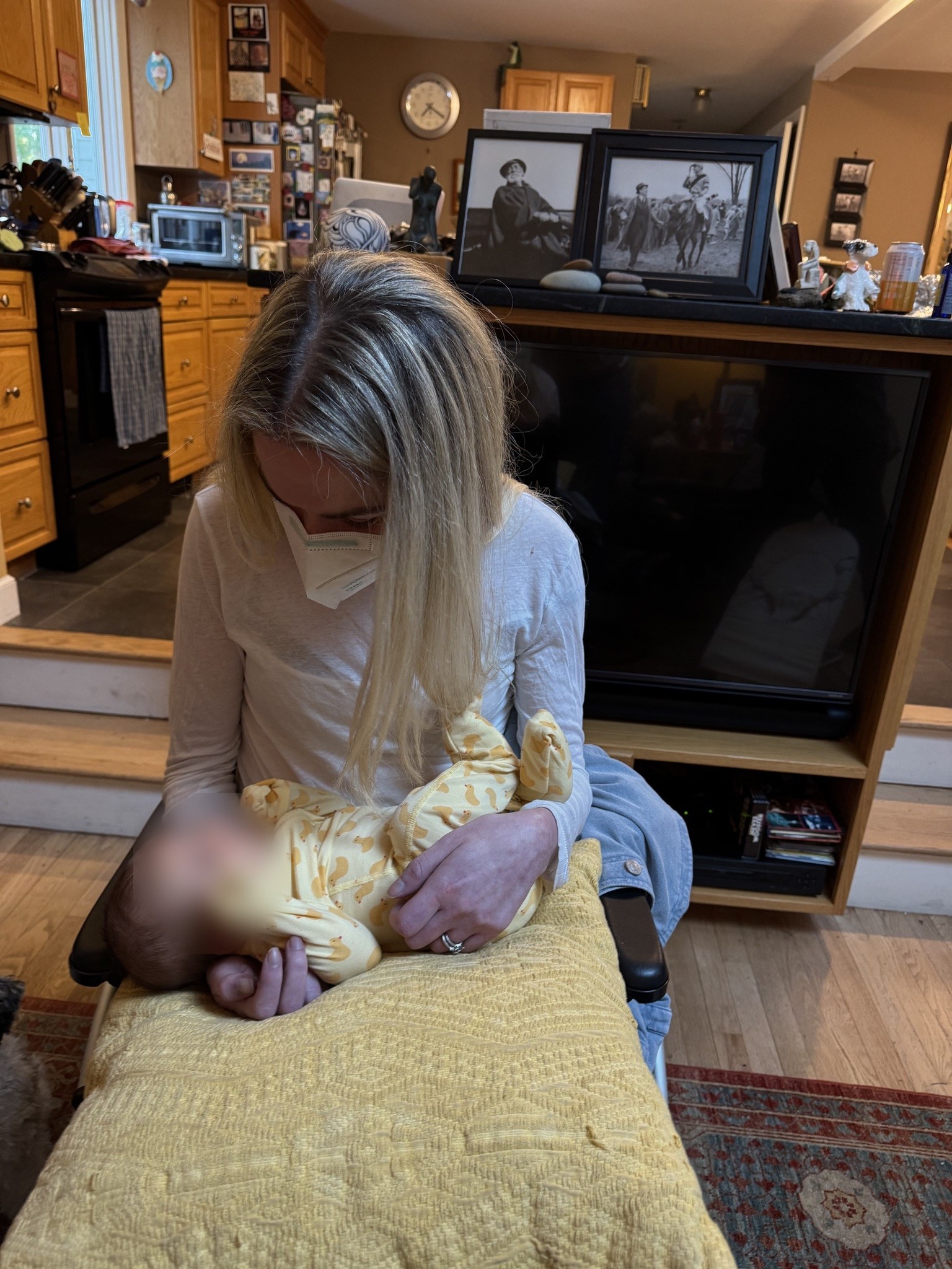 Anna in her wheelchair at home, holding her baby niece on a pillow in her lap