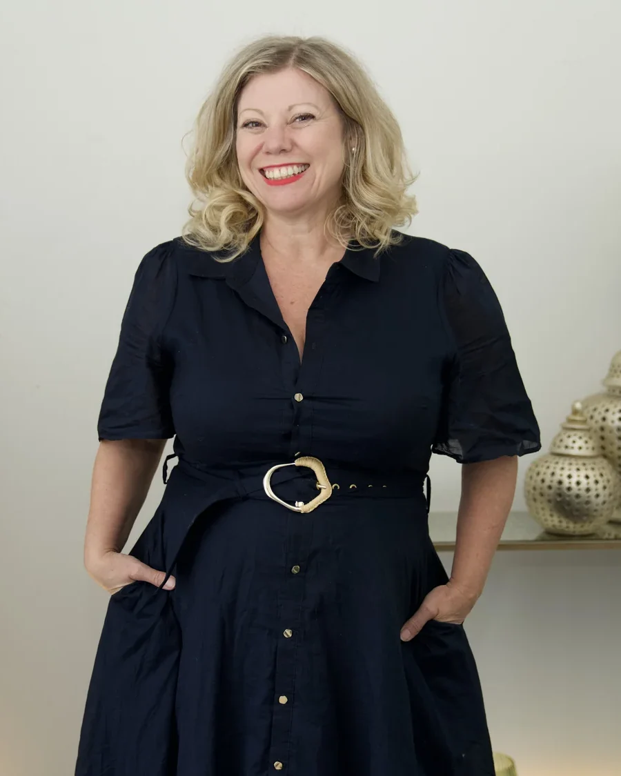 Deb Szabo, AI Business Strategist, standing and smiling in a navy dress