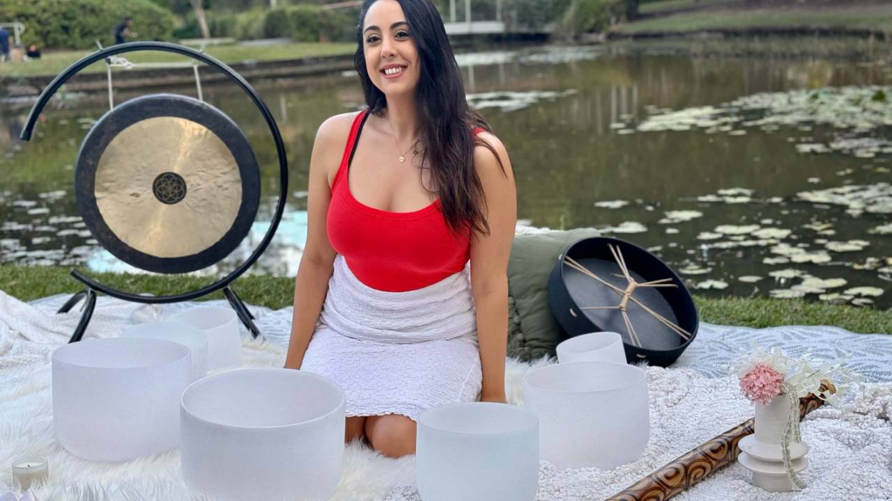 Sound healer facilitating a sound bath session with crystal singing bowls as part of a professional sound healing career