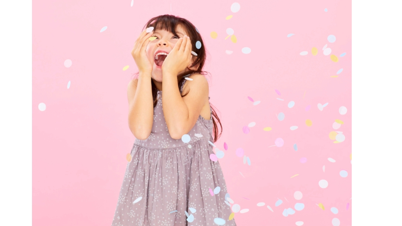 A joyful child celebrating with confetti, representing the excitement of starting a sleep success program