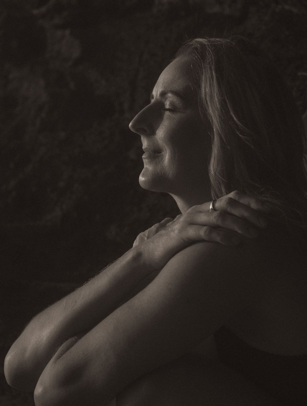 Rachel in profile, eyes closed, hand on her shoulder