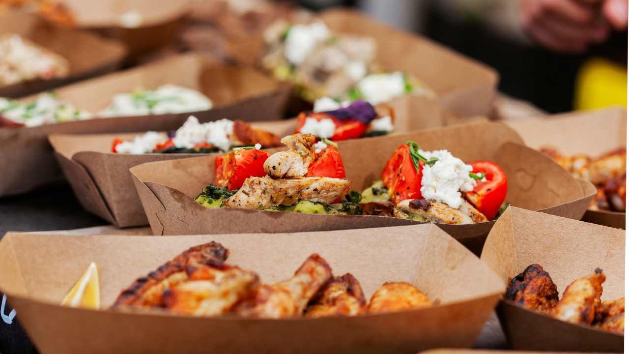 selection of dishes like chicken wings, salad in small paper cups