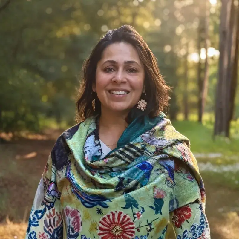 Anumeha Gupta, Inner Flowering Retreat host, smiling in the forest